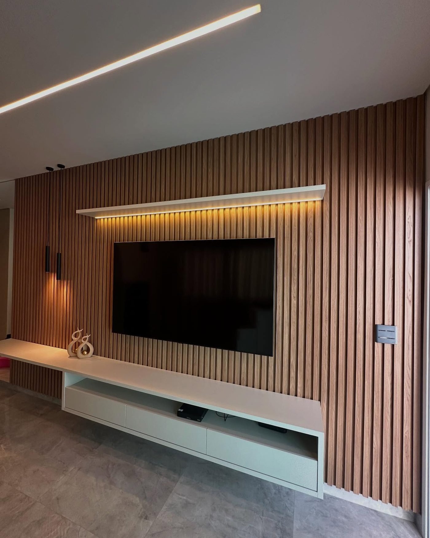 Sala de estar com painel de TV ripado e marcenaria integrada